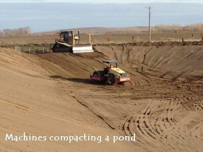Machines working in a large pond